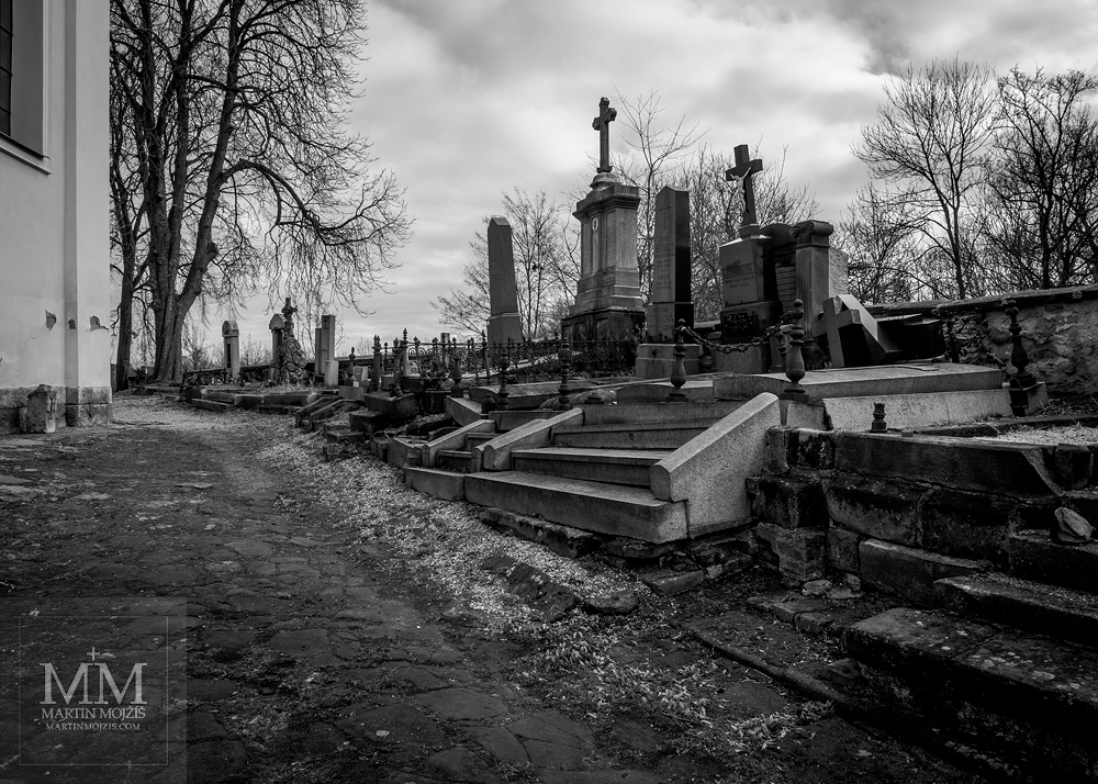 Cemetery near the church, black and white photograph. Photograph created with Olympus 12 - 40 mm 2.8 Pro lens.
